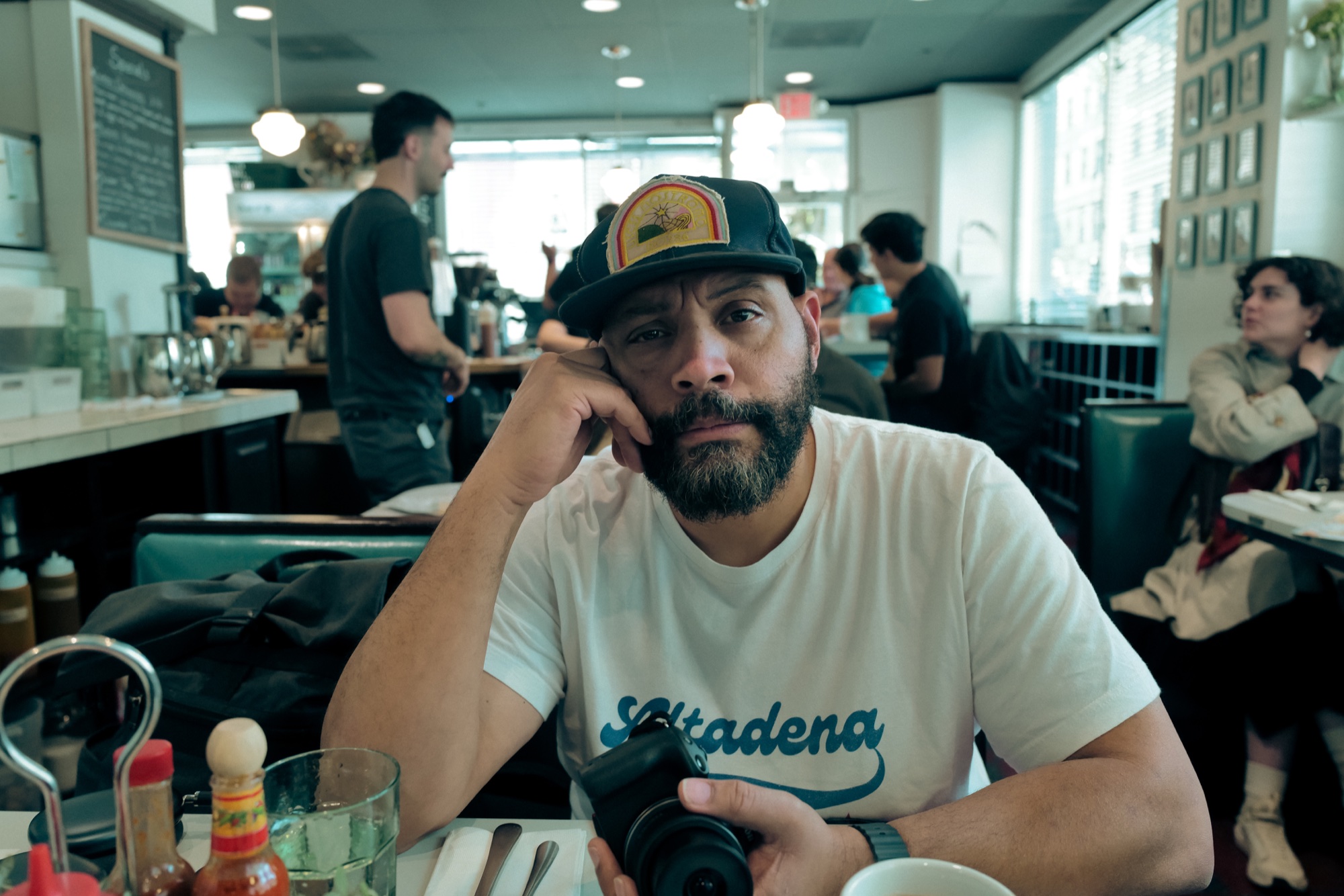 Colton Dunn sitting at a diner with a camera